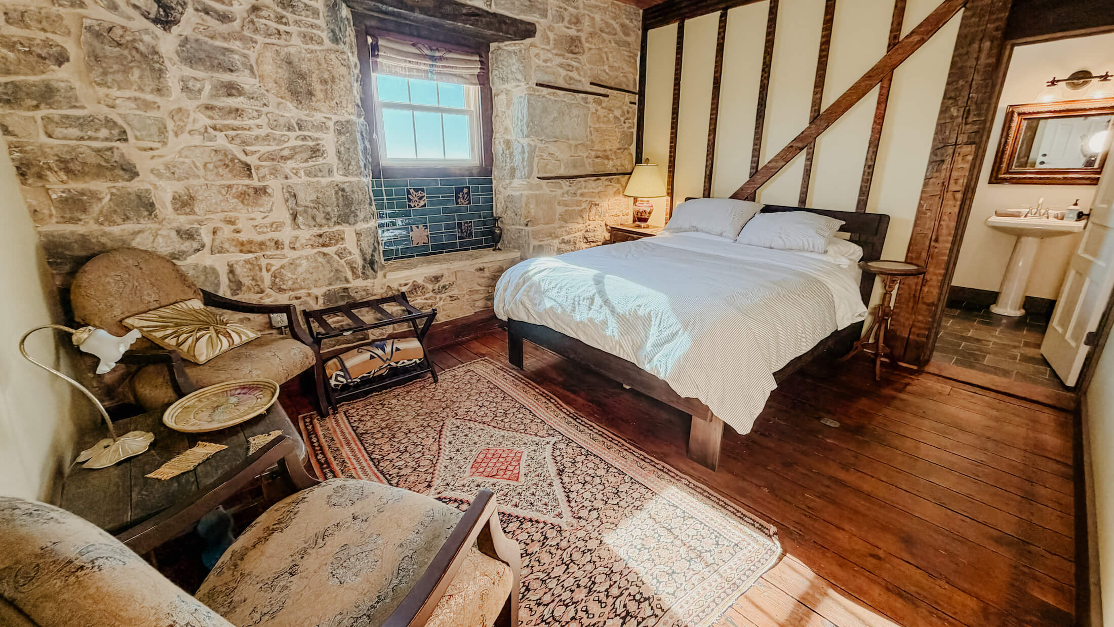 A room inside the Lion and Porcupine Inn in Mineral Point, with a bed and chairs. The Burrow.